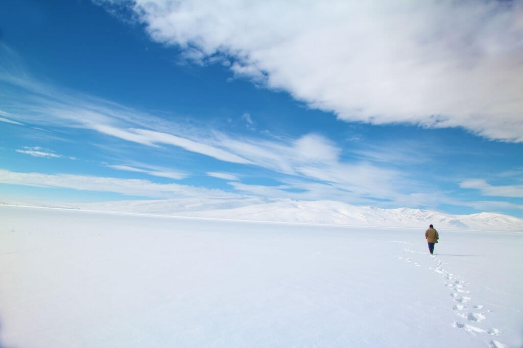 Buz tutmuş Çıldır Gölü üzerinde yürüyen insan
