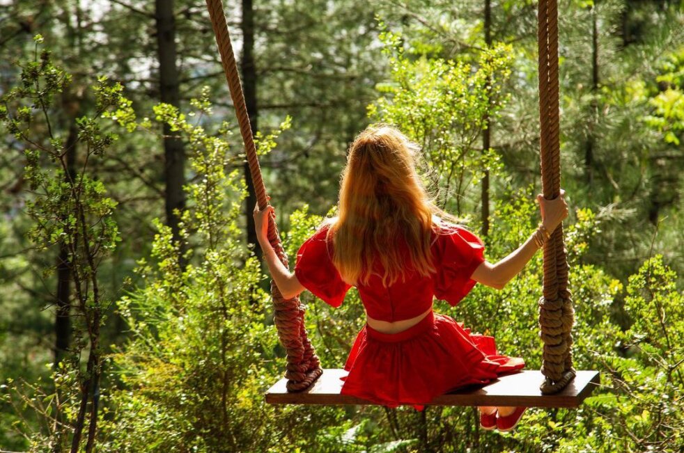 turkcell platinum park neler var, doğa manzarasına karşı salıncakta sallanan kırmızı elbiseli kadın