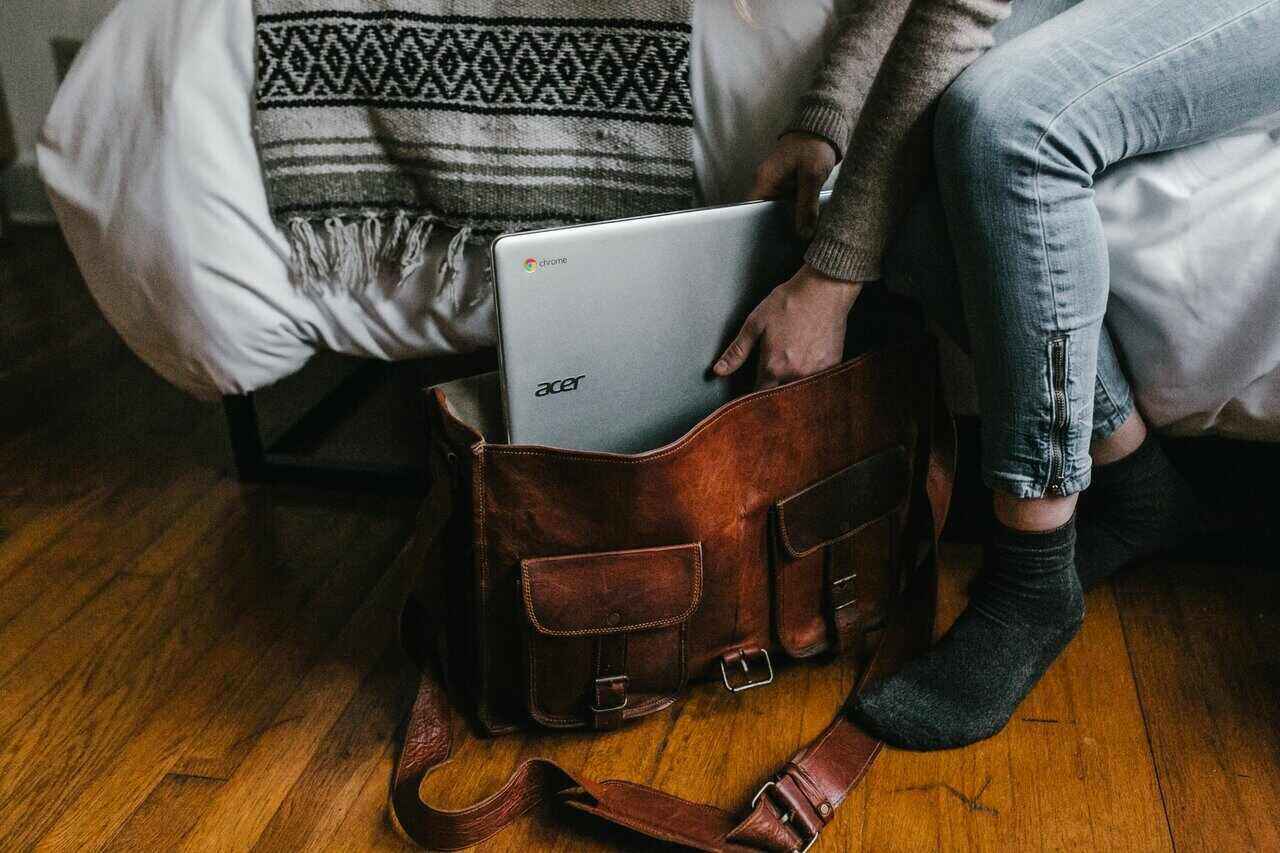 seyahat çantasına bilgisayar koyan gezgin
