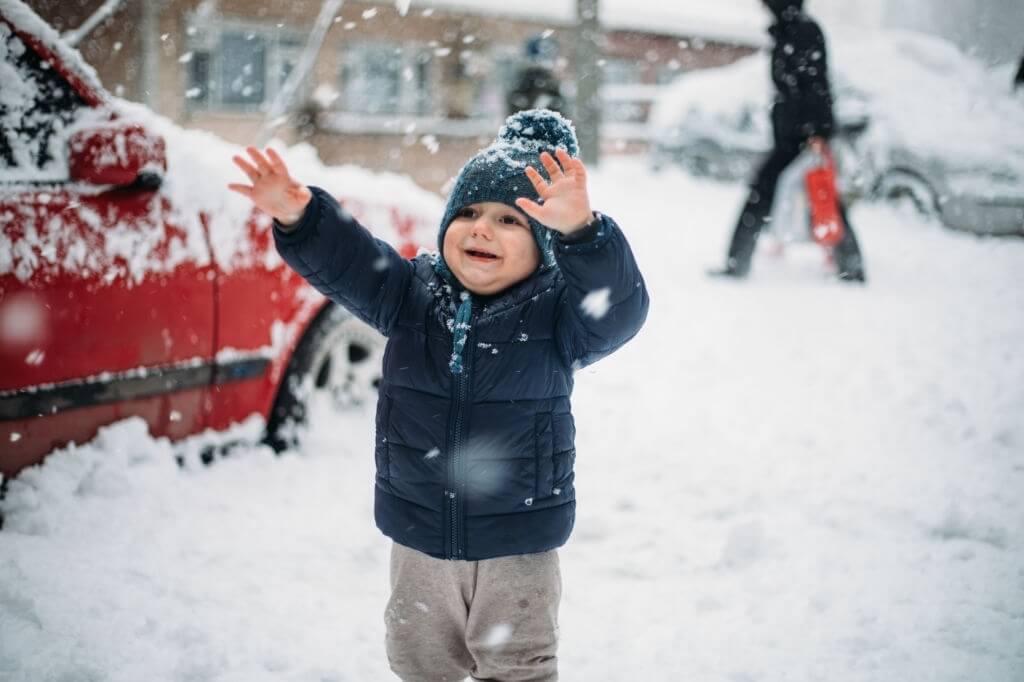 aralıkta gezilecek yerler, kar üzerinde oynayan küçük çocuk