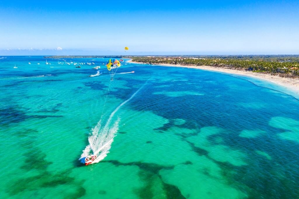 Dominik Cumhuriyeti'nde Bavaro Plajı, Punta Cana yakınlarında parasailing turistler. Tropikal tesisin havadan görünümü